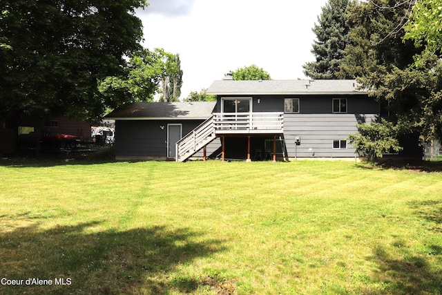 rear view of property featuring stairway, a deck, a yard, and a chimney