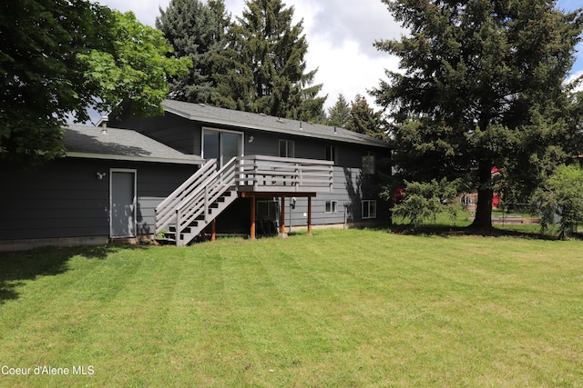 back of house with stairway, a yard, and a wooden deck