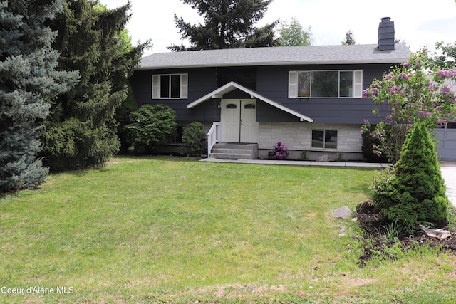 bi-level home with a chimney, a front lawn, and a shingled roof