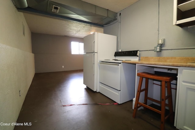 kitchen featuring white appliances, concrete floors, and light countertops