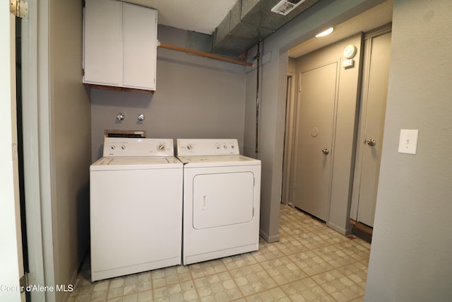 washroom featuring washer and clothes dryer, light floors, and cabinet space