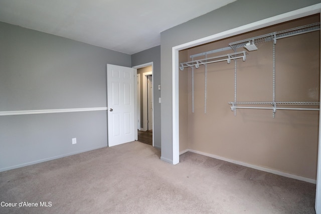 unfurnished bedroom featuring carpet, a closet, and baseboards
