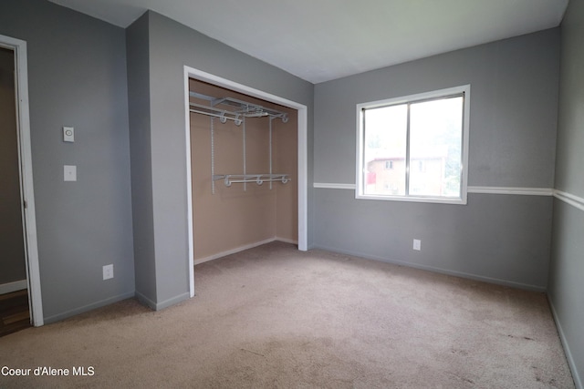 unfurnished bedroom featuring carpet flooring, baseboards, and a closet