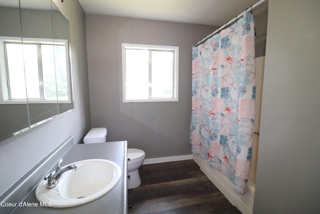 full bath with wood finished floors, toilet, vanity, shower / bath combo, and baseboards
