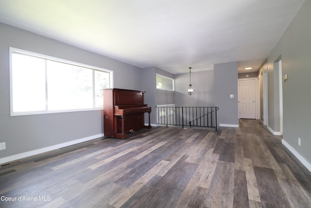 unfurnished living room featuring dark wood finished floors and baseboards