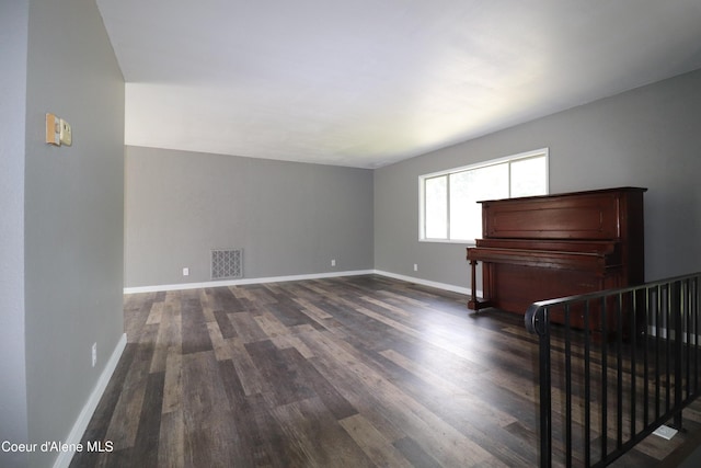 unfurnished living room with dark wood finished floors and baseboards