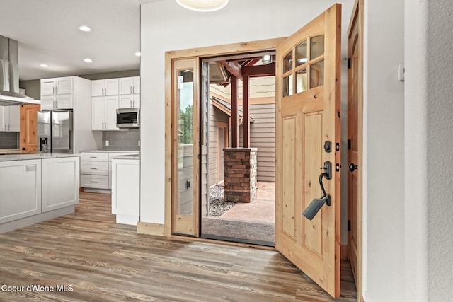 24 Bellflower Ct, Blanchard, ID 83804 - kitchen with stainless steel appliances, light wood-style flooring, extractor fan, white cabinets, and recessed lighting