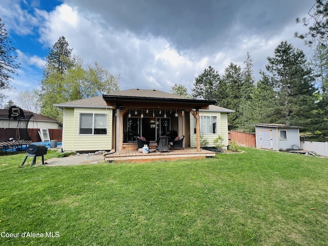 8351 N Audubon Dr, Hayden, ID 83835 - rear view of house featuring a trampoline, a shed, and an outbuilding