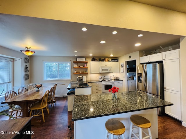 8351 N Audubon Dr, Hayden, ID 83835 - kitchen with white appliances, dark wood-style flooring, a sink, recessed lighting, and white cabinets
