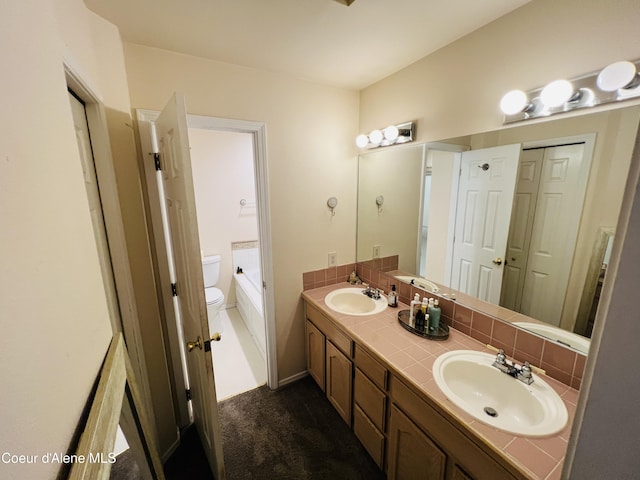 8351 N Audubon Dr, Hayden, ID 83835 - bathroom featuring toilet, double vanity, and a tub to relax in
