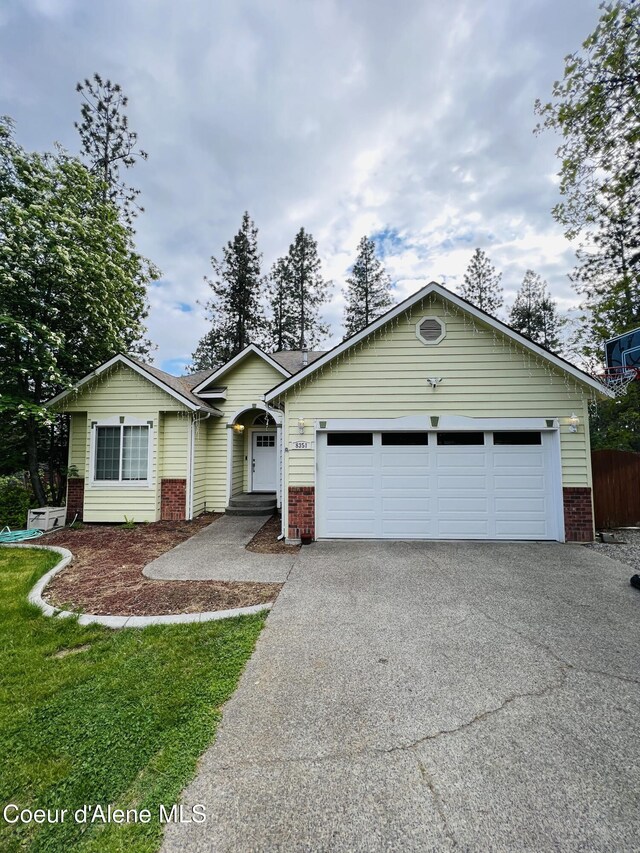 8351 N Audubon Dr, Hayden, ID 83835 - ranch-style home with brick siding, driveway, and an attached garage