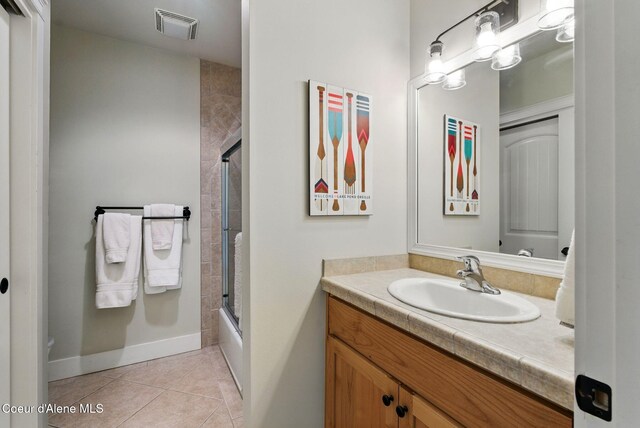 500 Guthrie Pl Unit 1303, Dover, ID 83825 - bathroom featuring vanity, tile patterned flooring, baseboards, and enclosed tub / shower combo