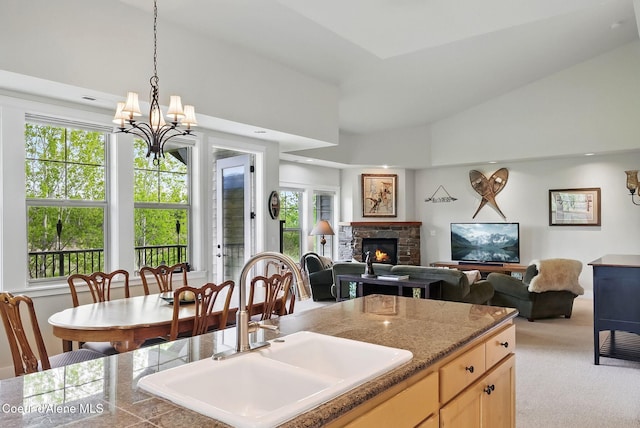 500 Guthrie Pl Unit 1303, Dover, ID 83825 - kitchen featuring a sink, light colored carpet, a stone fireplace, hanging light fixtures, and light brown cabinets