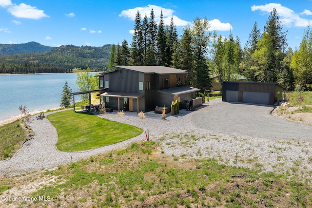 55 S Thistle Down Ln, Laclede, ID 83841 - view of front facade featuring a water and mountain view, a wooded view, a detached garage, and an outdoor structure