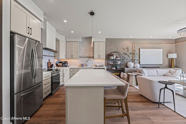55 S Thistle Down Ln, Laclede, ID 83841 - kitchen with appliances with stainless steel finishes, a sink, open floor plan, a breakfast bar, and a kitchen island