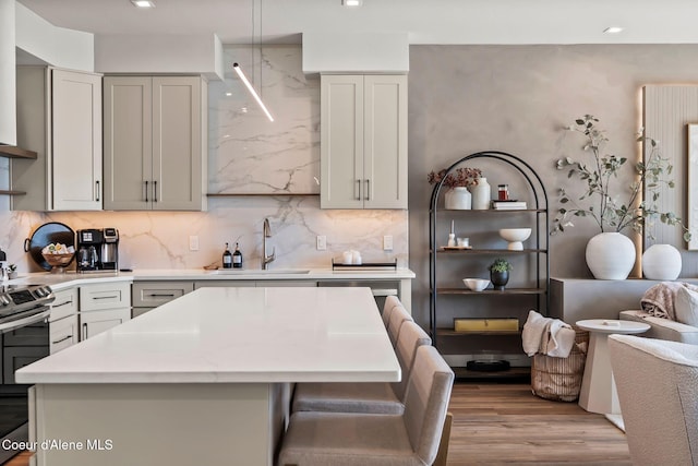 55 S Thistle Down Ln, Laclede, ID 83841 - kitchen featuring electric stove, a sink, light wood-style floors, a kitchen island, and decorative backsplash