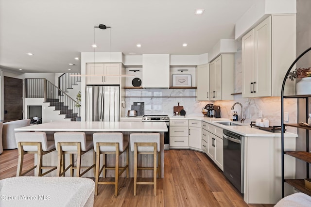 55 S Thistle Down Ln, Laclede, ID 83841 - kitchen with stainless steel appliances, a sink, a breakfast bar area, wood finished floors, and a center island