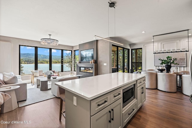 55 S Thistle Down Ln, Laclede, ID 83841 - kitchen featuring open floor plan, stainless steel microwave, wood finished floors, light countertops, and a kitchen island