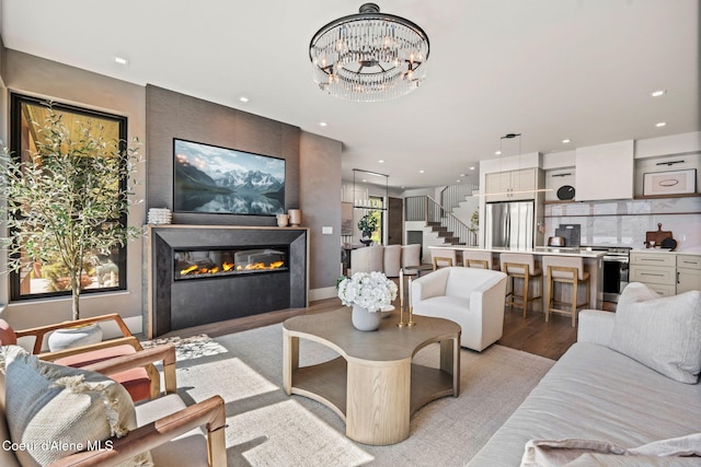 55 S Thistle Down Ln, Laclede, ID 83841 - living area featuring light wood-type flooring, a glass covered fireplace, recessed lighting, a chandelier, and stairs