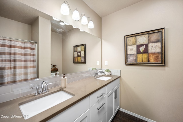 full bathroom featuring decorative backsplash, double vanity, baseboards, and wood finished floors