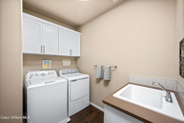laundry room featuring washing machine and dryer, cabinet space, dark wood-style floors, and baseboards