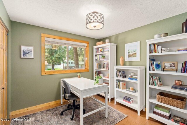 office space with wood finished floors, baseboards, and a textured ceiling