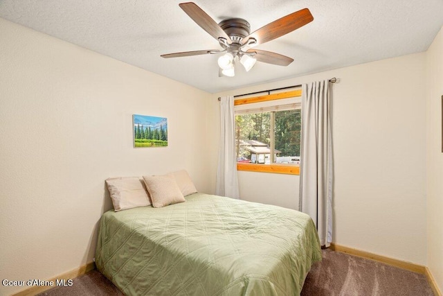 bedroom with carpet floors, baseboards, ceiling fan, and a textured ceiling