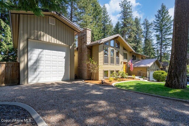 view of front of home featuring gravel driveway, an outdoor structure, and a chimney