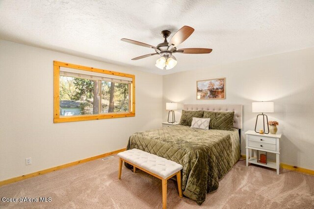 bedroom with carpet floors, baseboards, a textured ceiling, and a ceiling fan