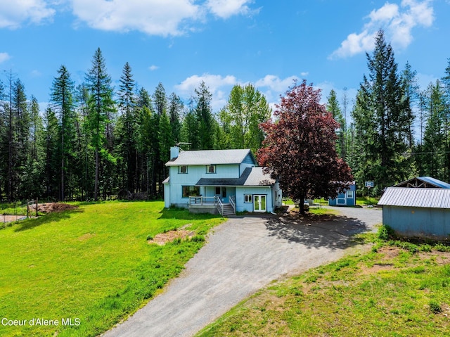 6699 Colburn Culver Rd, Sandpoint, ID 83864 - view of front of house with a front yard, dirt driveway, and a chimney