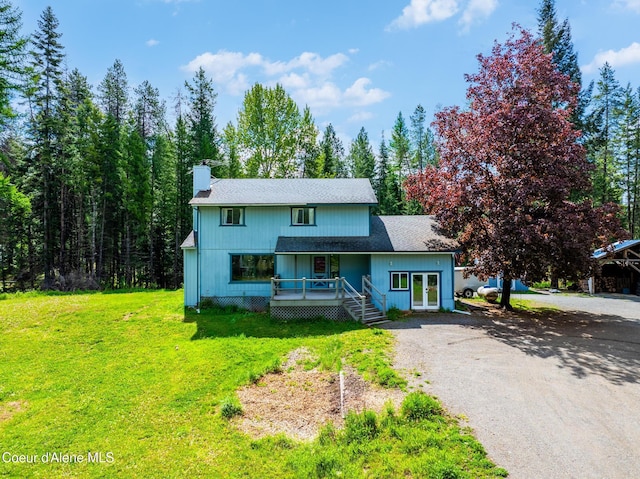 6699 Colburn Culver Rd, Sandpoint, ID 83864 - view of front facade featuring french doors, a chimney, a front yard, gravel driveway, and a shingled roof