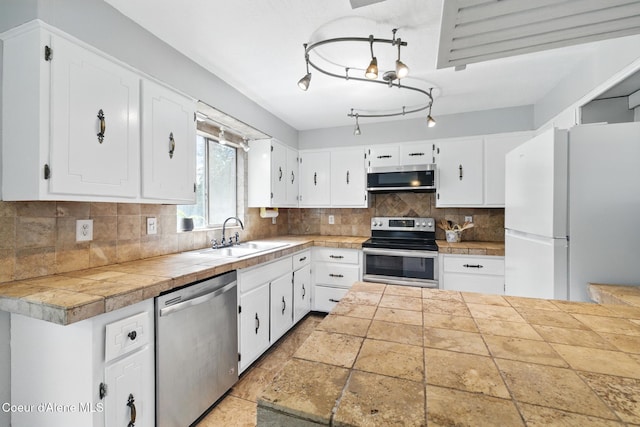 6699 Colburn Culver Rd, Sandpoint, ID 83864 - kitchen with stainless steel appliances, a sink, white cabinetry, and decorative backsplash