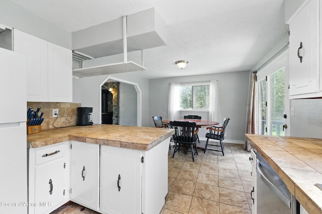 6699 Colburn Culver Rd, Sandpoint, ID 83864 - kitchen with freestanding refrigerator, a peninsula, dishwasher, white cabinets, and light countertops