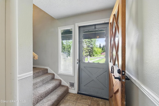 6699 Colburn Culver Rd, Sandpoint, ID 83864 - foyer entrance featuring a textured wall, tile patterned flooring, and stairs