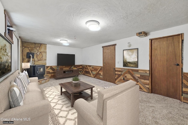 6699 Colburn Culver Rd, Sandpoint, ID 83864 - living room with carpet flooring, a wood stove, and a textured ceiling