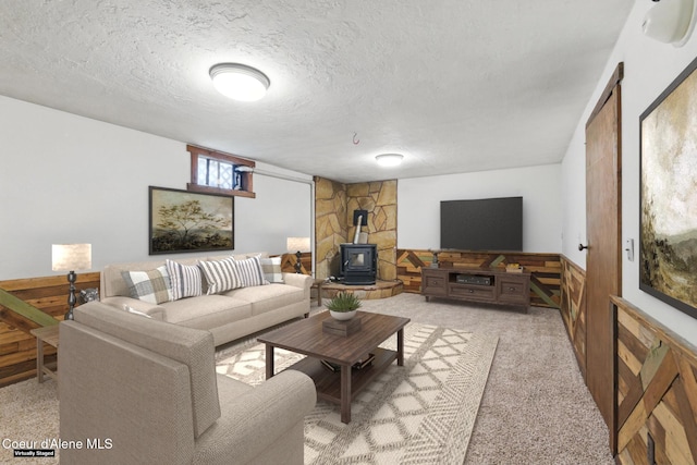 6699 Colburn Culver Rd, Sandpoint, ID 83864 - living room with a wood stove, light carpet, a textured ceiling, and wainscoting