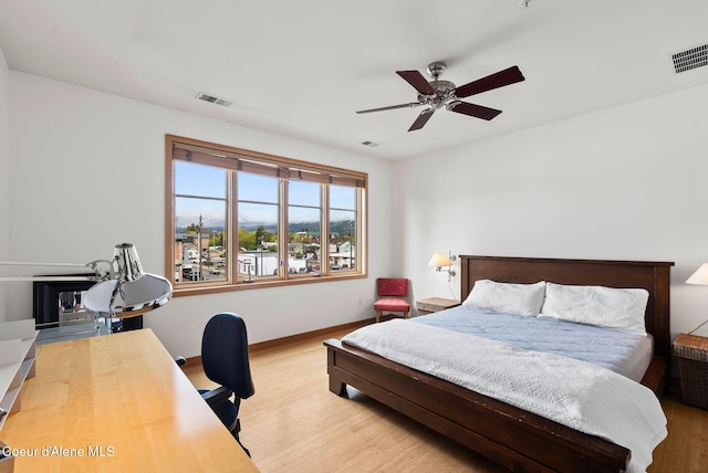 bedroom featuring wood finished floors, a desk, baseboards, and ceiling fan