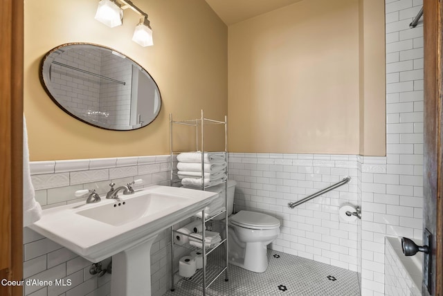 bathroom with tile walls, toilet, tile patterned floors, and wainscoting