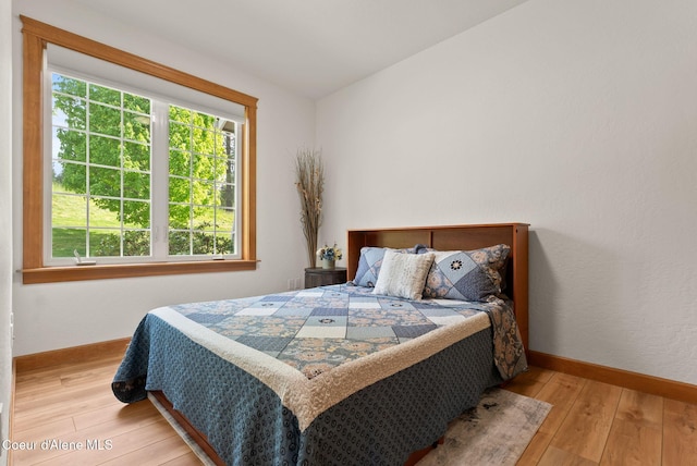 4461 W Greenchain Loop # 5, Coeur Dalene, ID 83814 - bedroom featuring multiple windows, light wood-style flooring, and baseboards