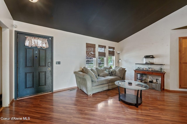 living area featuring vaulted ceiling, wood finished floors, and baseboards
