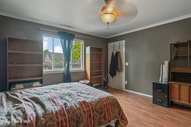 bedroom with wood finished floors, ornamental molding, baseboards, a ceiling fan, and a closet