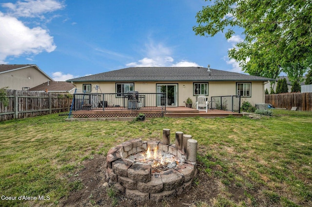 back of house with an outdoor fire pit and a deck