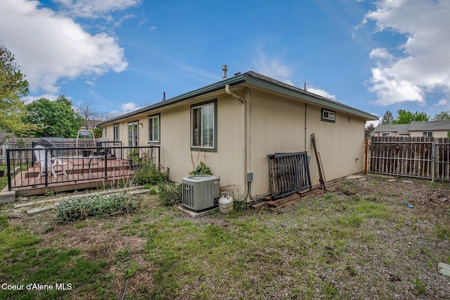 view of property exterior featuring central AC unit, a fenced backyard, and a deck