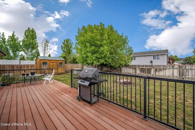 wooden terrace with grilling area, an outbuilding, outdoor dining area, and a storage shed