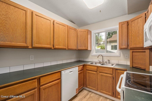 8694 N Clarkview Pl, Hayden Lake, ID 83835 - kitchen featuring white appliances, a sink, dark countertops, light wood-type flooring, and a textured ceiling