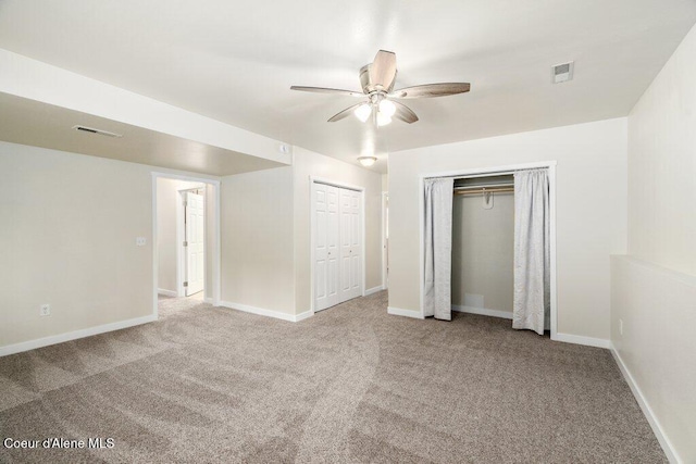 8694 N Clarkview Pl, Hayden Lake, ID 83835 - unfurnished bedroom with carpet floors, multiple closets, baseboards, and ceiling fan