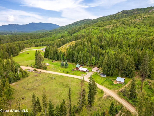 bird's eye view of a heavily wooded area and a mountainous background