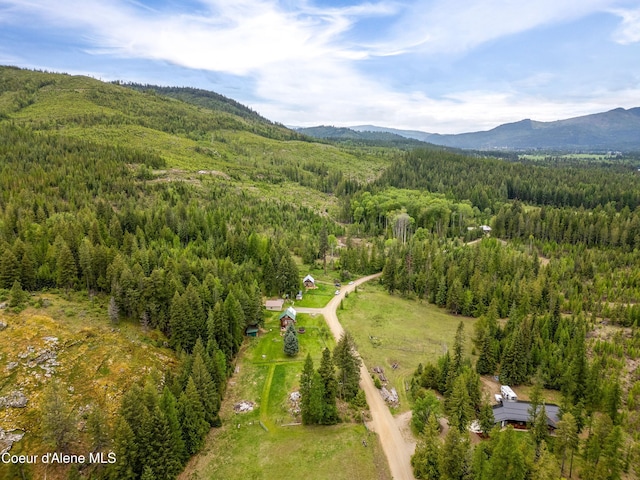 aerial overview of property's location featuring a heavily wooded area and a mountain backdrop