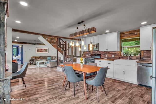 dining room featuring stairway, wood finished floors, ceiling fan, and recessed lighting