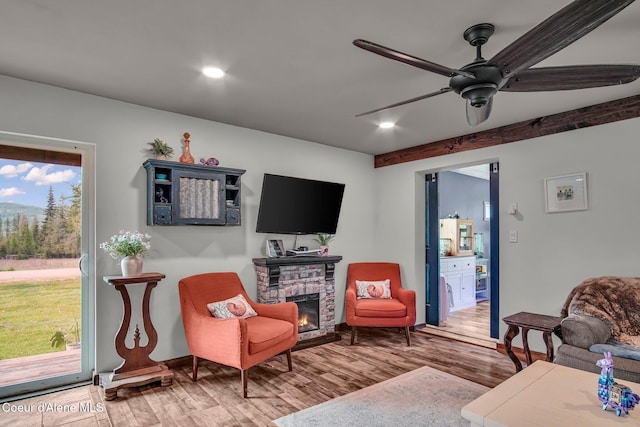 living area with wood finished floors, ceiling fan, recessed lighting, a fireplace, and baseboards
